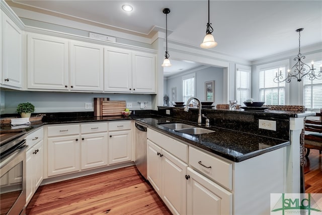 kitchen with kitchen peninsula, ornamental molding, light wood-type flooring, white cabinets, and sink