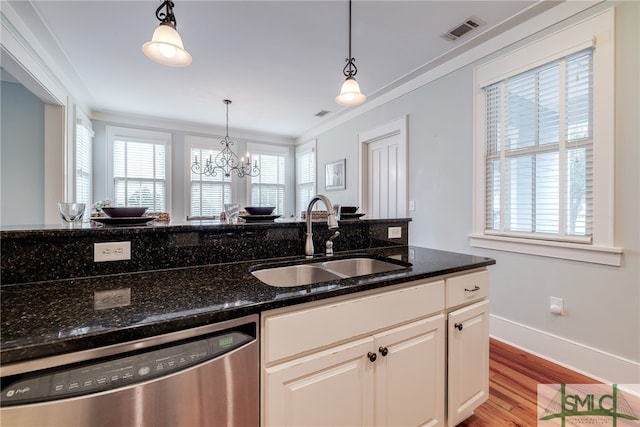 kitchen featuring crown molding, dishwasher, light wood-type flooring, dark stone countertops, and sink