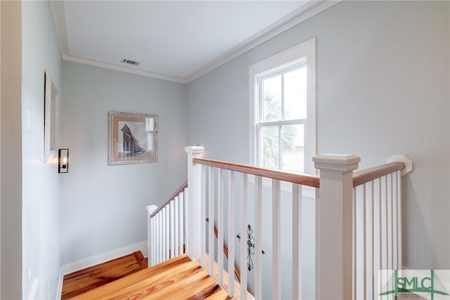 stairway with ornamental molding and hardwood / wood-style flooring