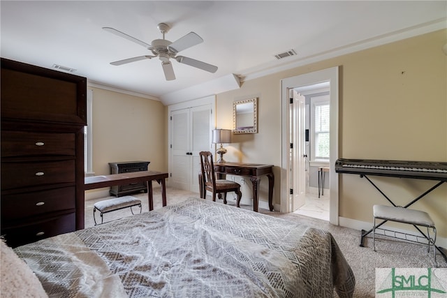 carpeted bedroom featuring ceiling fan, a closet, and ornamental molding