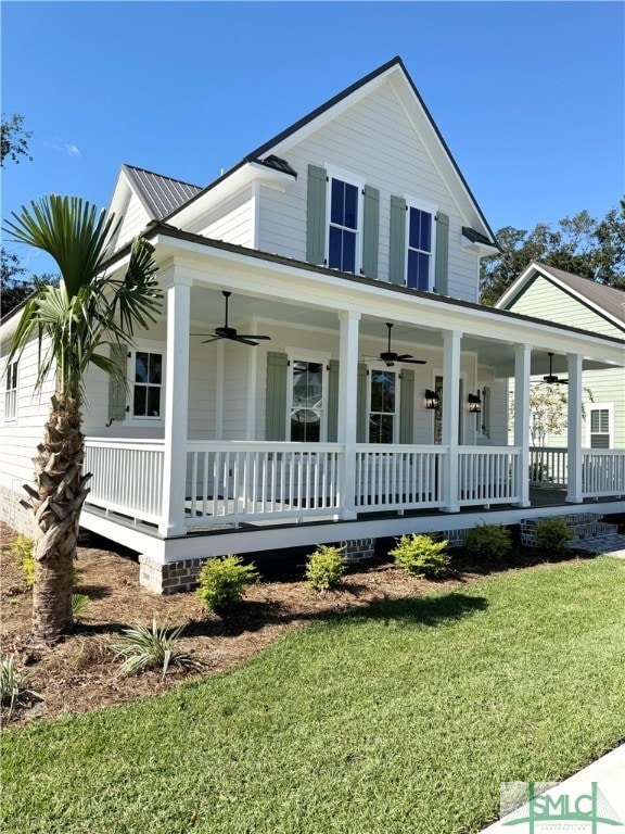 farmhouse-style home featuring ceiling fan, a front yard, and covered porch