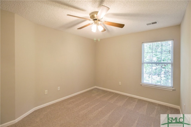 spare room featuring a textured ceiling, carpet, and ceiling fan