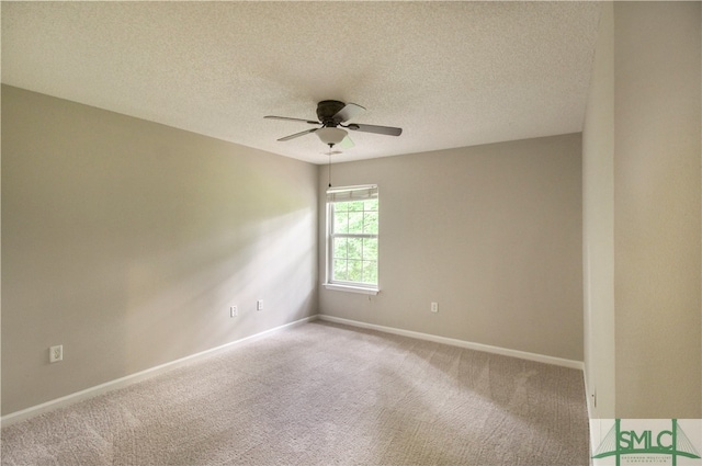 spare room featuring a textured ceiling, carpet, and ceiling fan