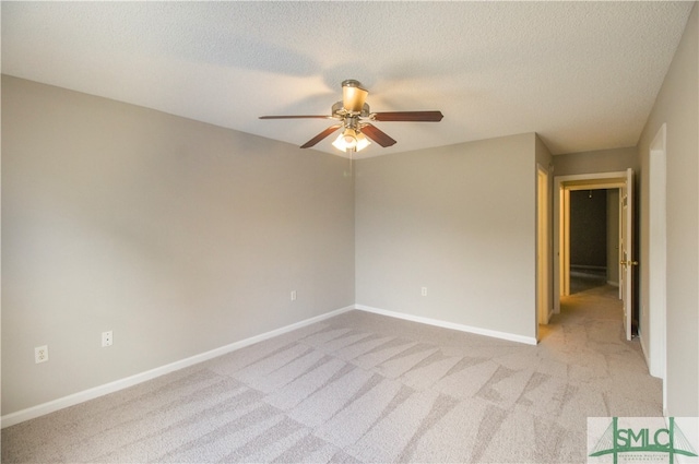 unfurnished room featuring ceiling fan, a textured ceiling, and light colored carpet