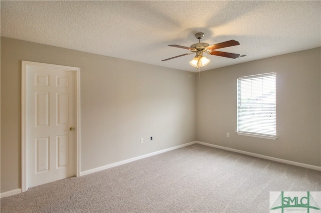 carpeted empty room with ceiling fan and a textured ceiling