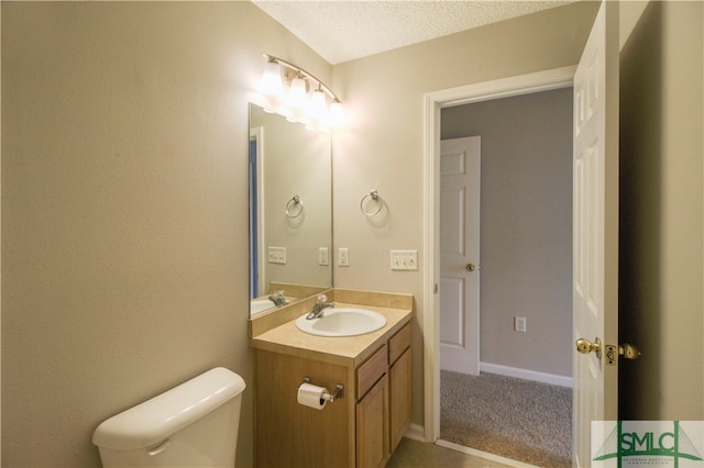 bathroom with a textured ceiling, oversized vanity, and toilet