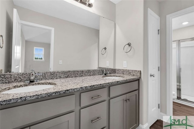 bathroom featuring dual vanity, wood-type flooring, and toilet