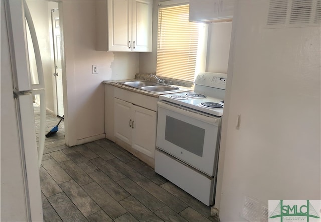 kitchen featuring dark hardwood / wood-style floors, sink, white cabinets, and white appliances