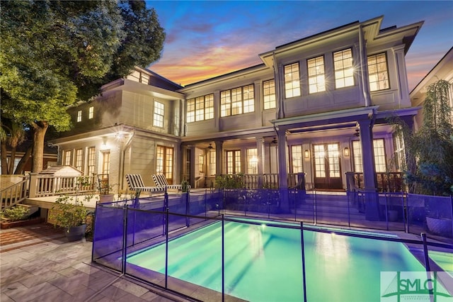 back house at dusk featuring a patio