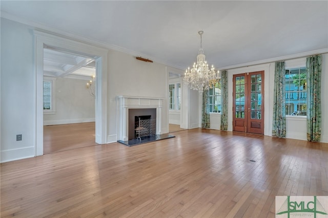 unfurnished living room featuring an inviting chandelier, light hardwood / wood-style floors, coffered ceiling, beam ceiling, and ornamental molding