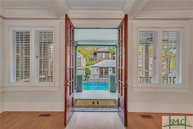 entryway featuring light wood-type flooring and crown molding