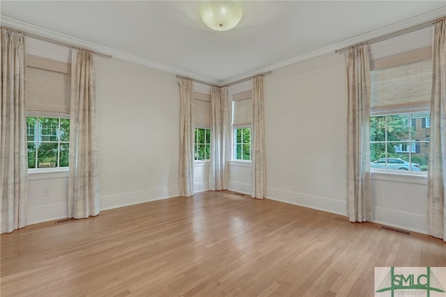 unfurnished room featuring light hardwood / wood-style floors and crown molding