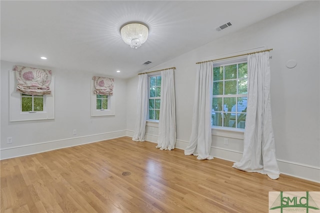 empty room featuring light wood-type flooring and vaulted ceiling