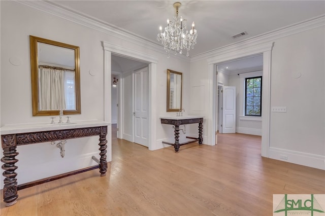 interior space with crown molding, light hardwood / wood-style flooring, and a notable chandelier