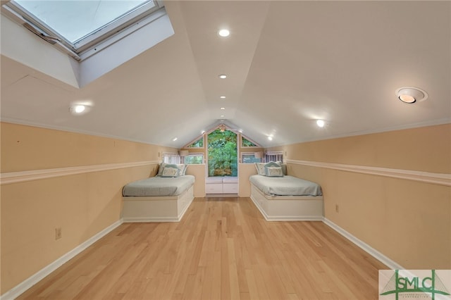 bonus room with light hardwood / wood-style flooring and vaulted ceiling with skylight