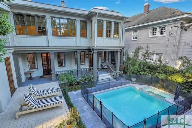 back of property featuring a fenced in pool