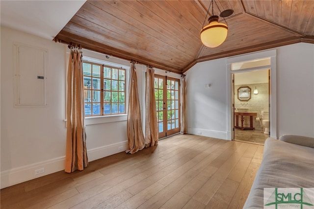 unfurnished living room with lofted ceiling, electric panel, light wood-type flooring, and wood ceiling