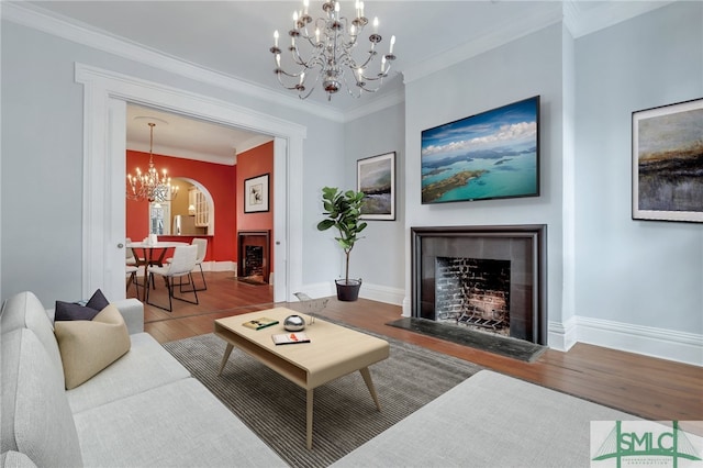 living room featuring a chandelier, hardwood / wood-style flooring, and ornamental molding