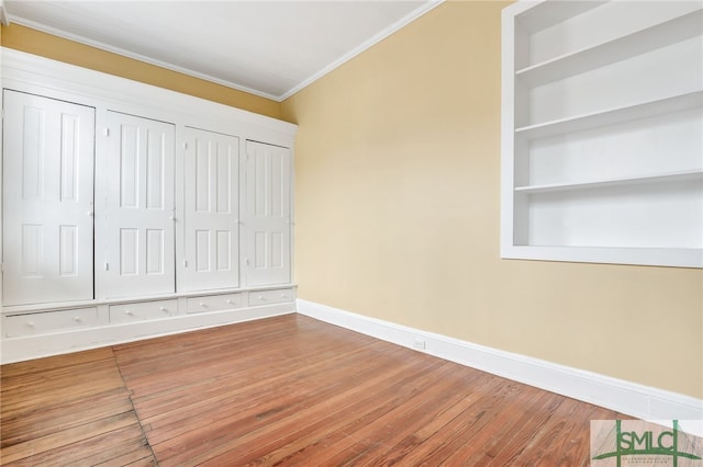 unfurnished bedroom featuring ornamental molding and hardwood / wood-style flooring