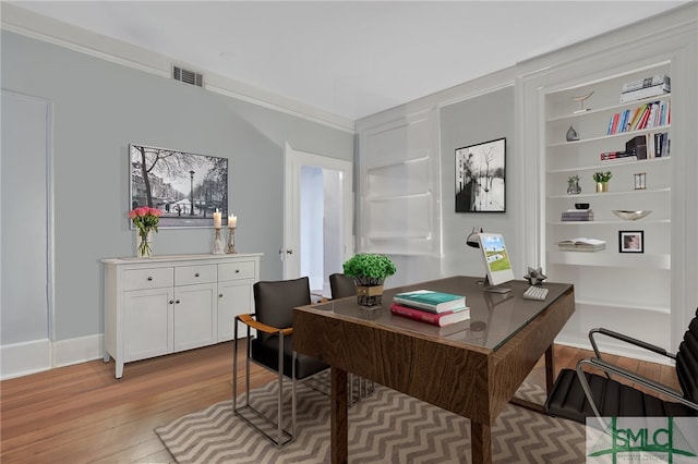 office with light wood-type flooring and crown molding