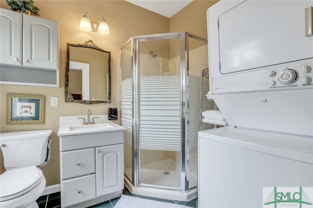 bathroom featuring toilet, a shower with shower door, stacked washer and clothes dryer, tile flooring, and large vanity