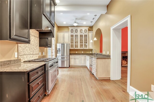 kitchen featuring dark brown cabinets, ceiling fan, light hardwood / wood-style floors, light stone countertops, and stainless steel appliances