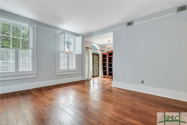 unfurnished living room featuring a chandelier and hardwood / wood-style flooring