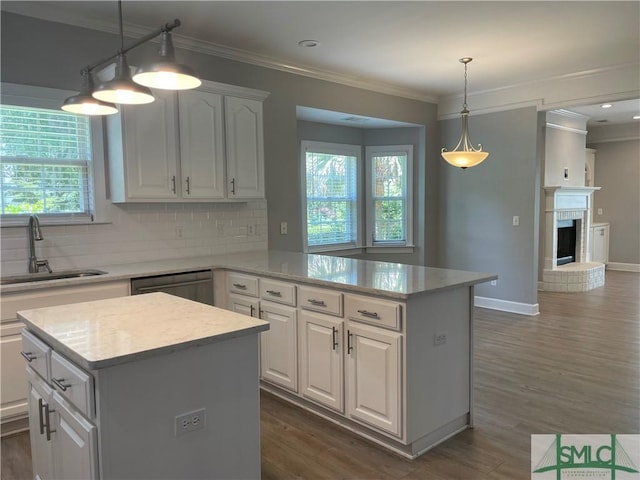 kitchen with white cabinetry, sink, backsplash, a center island, and stainless steel dishwasher