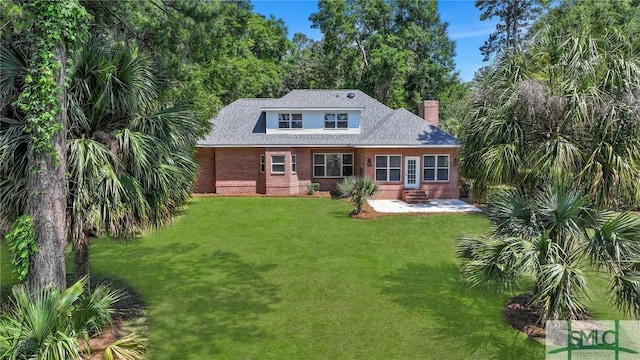 rear view of house featuring a lawn