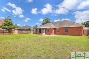 back of house featuring a lawn and a fenced backyard