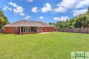 rear view of property with a yard and a fenced backyard