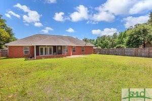 back of house featuring a lawn and a fenced backyard