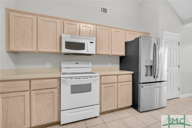 kitchen featuring white appliances, light countertops, and light brown cabinetry