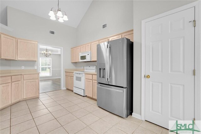 kitchen with high vaulted ceiling, a notable chandelier, light hardwood / wood-style flooring, white appliances, and light brown cabinetry