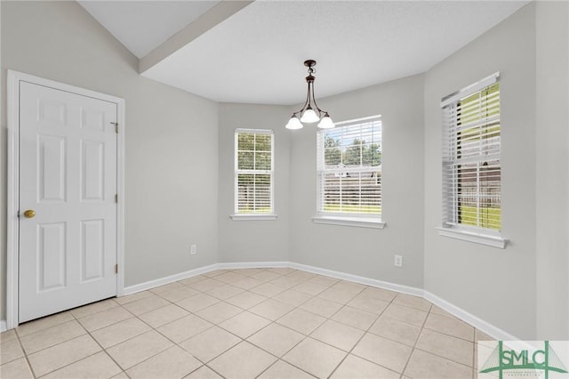 unfurnished room with light tile patterned floors, baseboards, and a chandelier