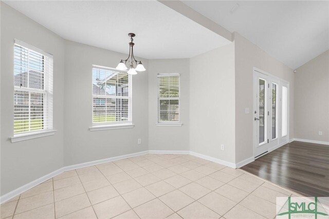 empty room featuring hardwood / wood-style flooring and a notable chandelier