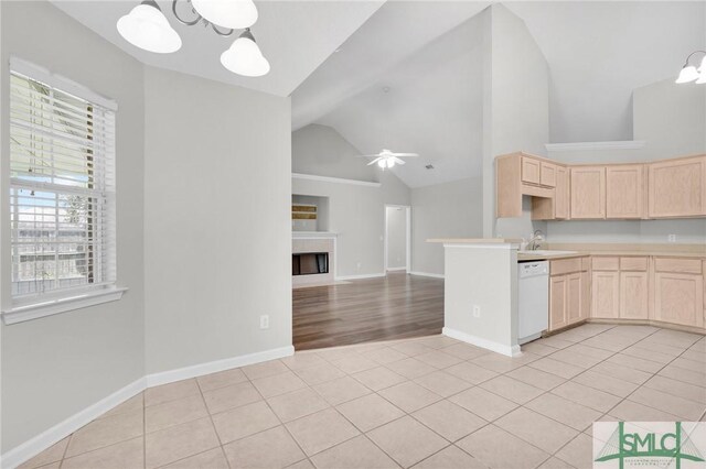 kitchen featuring ceiling fan with notable chandelier, light tile patterned floors, light brown cabinetry, and dishwasher