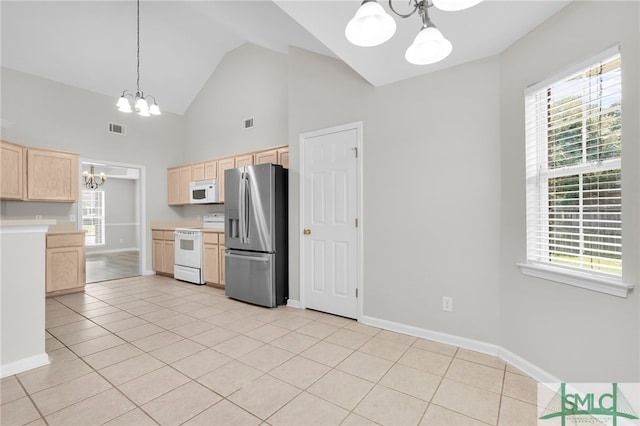 kitchen with light tile patterned flooring, light brown cabinets, an inviting chandelier, and white appliances