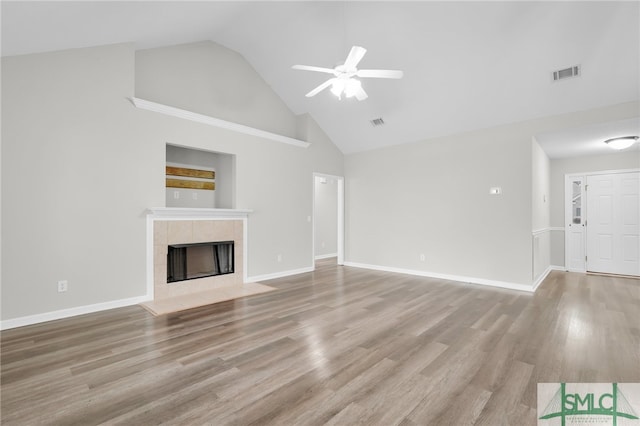 unfurnished living room featuring ceiling fan, a fireplace, high vaulted ceiling, and hardwood / wood-style floors