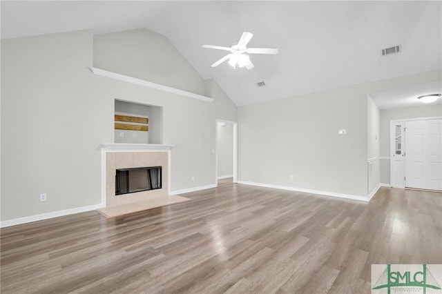 unfurnished living room featuring visible vents, a ceiling fan, wood finished floors, and a fireplace