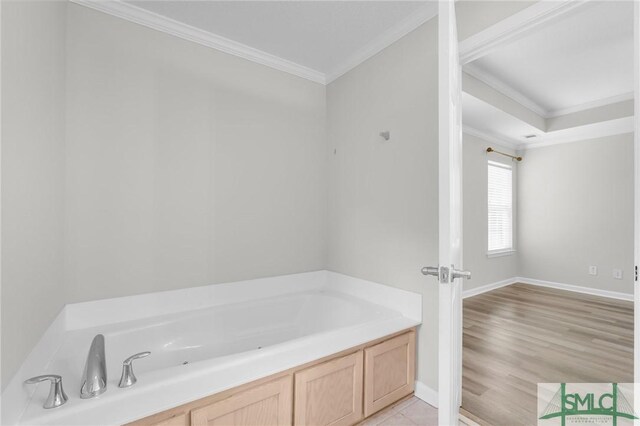 bathroom with a bathtub, hardwood / wood-style flooring, and crown molding