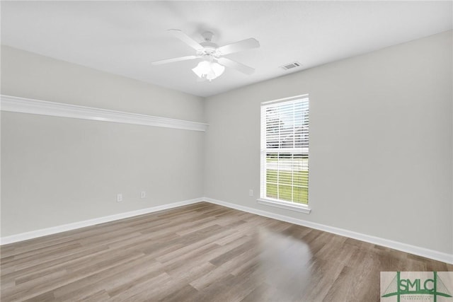 unfurnished room featuring ceiling fan, visible vents, baseboards, and wood finished floors