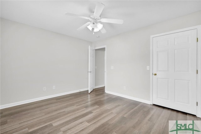 unfurnished bedroom with wood finished floors, baseboards, and ceiling fan