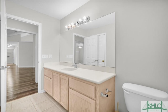 half bathroom featuring tile patterned floors, toilet, and vanity