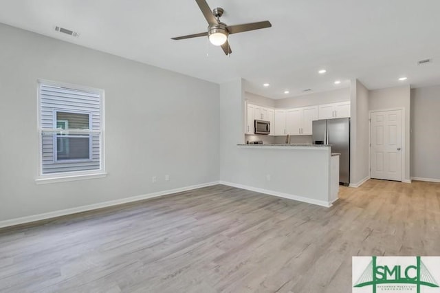 unfurnished living room with ceiling fan and light hardwood / wood-style flooring