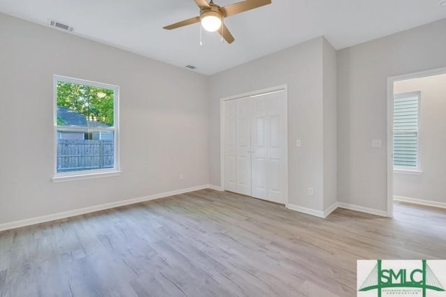 unfurnished bedroom with ceiling fan, light wood-type flooring, and a closet