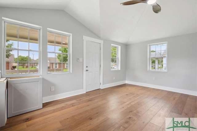 foyer with ceiling fan, vaulted ceiling, washer / dryer, and light hardwood / wood-style flooring