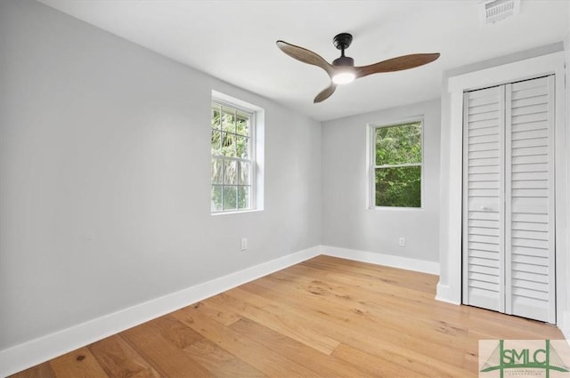 unfurnished bedroom with a closet, light hardwood / wood-style flooring, and ceiling fan