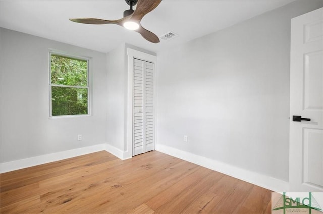 unfurnished bedroom featuring ceiling fan, light hardwood / wood-style floors, and a closet