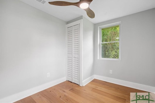 unfurnished bedroom with ceiling fan, light hardwood / wood-style flooring, and a closet